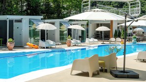 A pool area with lounge chairs, umbrellas, and a clear blue pool. - Yangpyeong Seojongpool pet Pension (Yangpyeong)