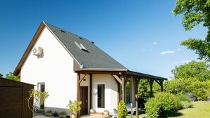 A single-story house with a sloped roof, a covered porch, and a gravel driveway. - Vacation home Lupo by Interhome (Balatonboglar)