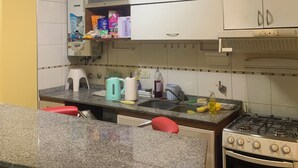 A kitchen with white cabinets, a Bosch oven, granite countertops, and various kitchen appliances. - Departamento Amplio Frente Parque Sarmiento 1 Cuadra a Terminal y Centro (Córdoba)
