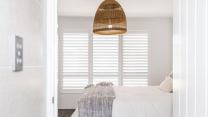 A bedroom with a bed, a woven pendant light, and white blinds. - Newly Built Luxury Modern Home (Dunsborough)