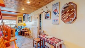Ein gemütliches Interieur mit Holzboden, einer Sofagarnitur, einem kleinen Tisch und einem Bild an der Wand.