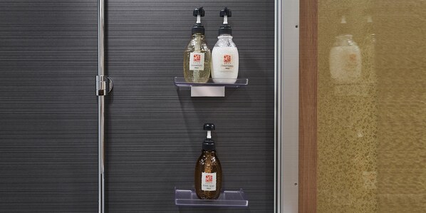 A bathroom with three shelves holding bottles of shampoo, conditioner, and body soap. - IZUTSU HOTEL KYOTO TAKASEGAWA BETTEI (Kyoto)