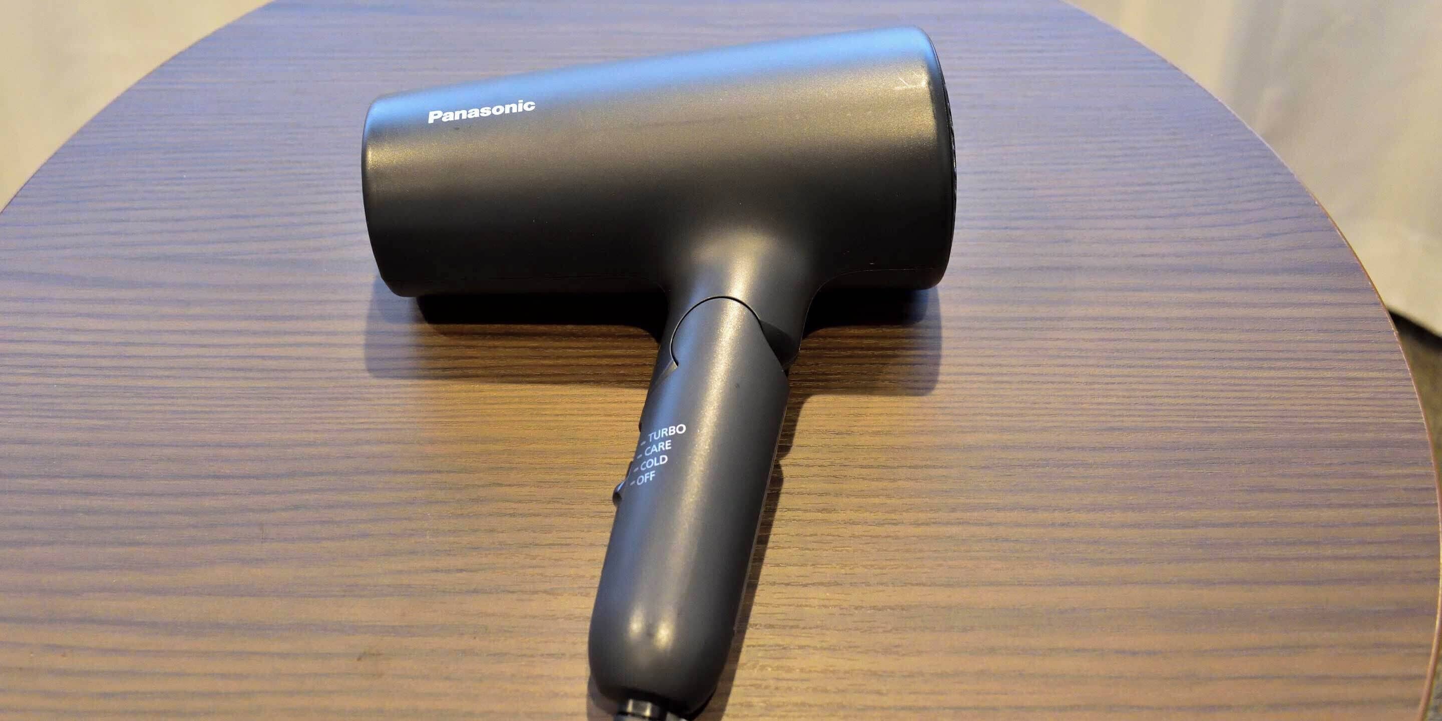 A Panasonic hair dryer on a wooden surface.