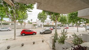Une vue de rue avec des voitures garées, des arbres et un trottoir.