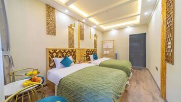 Habitación de hotel con dos camas, un escritorio con fruta y paneles decorativos en la pared.