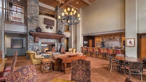 A spacious lobby with a fireplace, a bar area, and a seating area with patterned rugs and wooden furniture. - Welcome to Your 4BR/4BA Perfect Mountain Retreat in Park City (Park City)