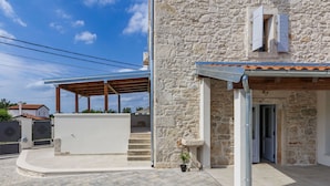A stone building with a covered patio and a small garden area. - Villa Lucky by Interhome (Poreč)