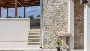 A stone building with a wooden pergola and a stone staircase leading to a balcony. - Villa Lucky by Interhome (Poreč)