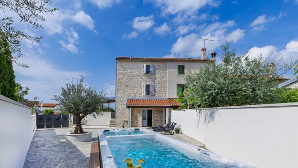 A swimming pool with a hot tub, surrounded by a stone building with a tiled roof. - Villa Lucky by Interhome (Poreč)