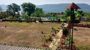 A landscaped garden with a gazebo, a swimming pool, and a view of distant mountains. - Presidency Highland Resort (Patan)