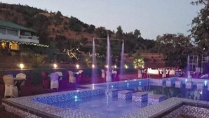 An outdoor pool area with tiled flooring and seating arrangements. - Presidency Highland Resort (Patan)