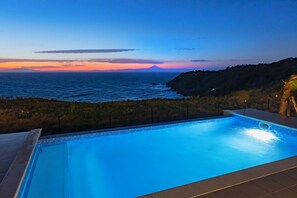 Relax by the oceanfront pool with a breathtaking view of the distant mountains.