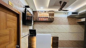 A modern kitchen with a wooden door, a built-in microwave, and a ceiling fan. - Sundaram Residency (Chennai)