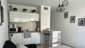 A modern, compact bedroom with a large bed, a small kitchenette, and a desk area. - Fully equipped studio in the center of Cannes with swimming pool, large terrace and air conditioning  (Cannes)