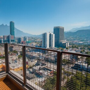 A high-rise building with a view of a cityscape and mountains in the background.