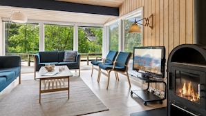 A cozy living room with a fireplace, a sofa, a coffee table, and a TV. - "Deni" - 800m from the sea by Interhome (Nexø)