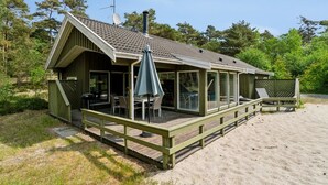 A wooden cabin with a deck, outdoor seating, and a satellite dish. - "Deni" - 800m from the sea by Interhome (Nexø)