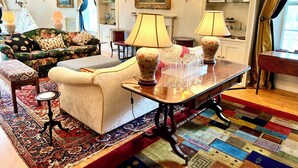 A well-furnished living room with a sofa, armchairs, a coffee table, and a patterned rug. - The Mill House (Ballasalla)