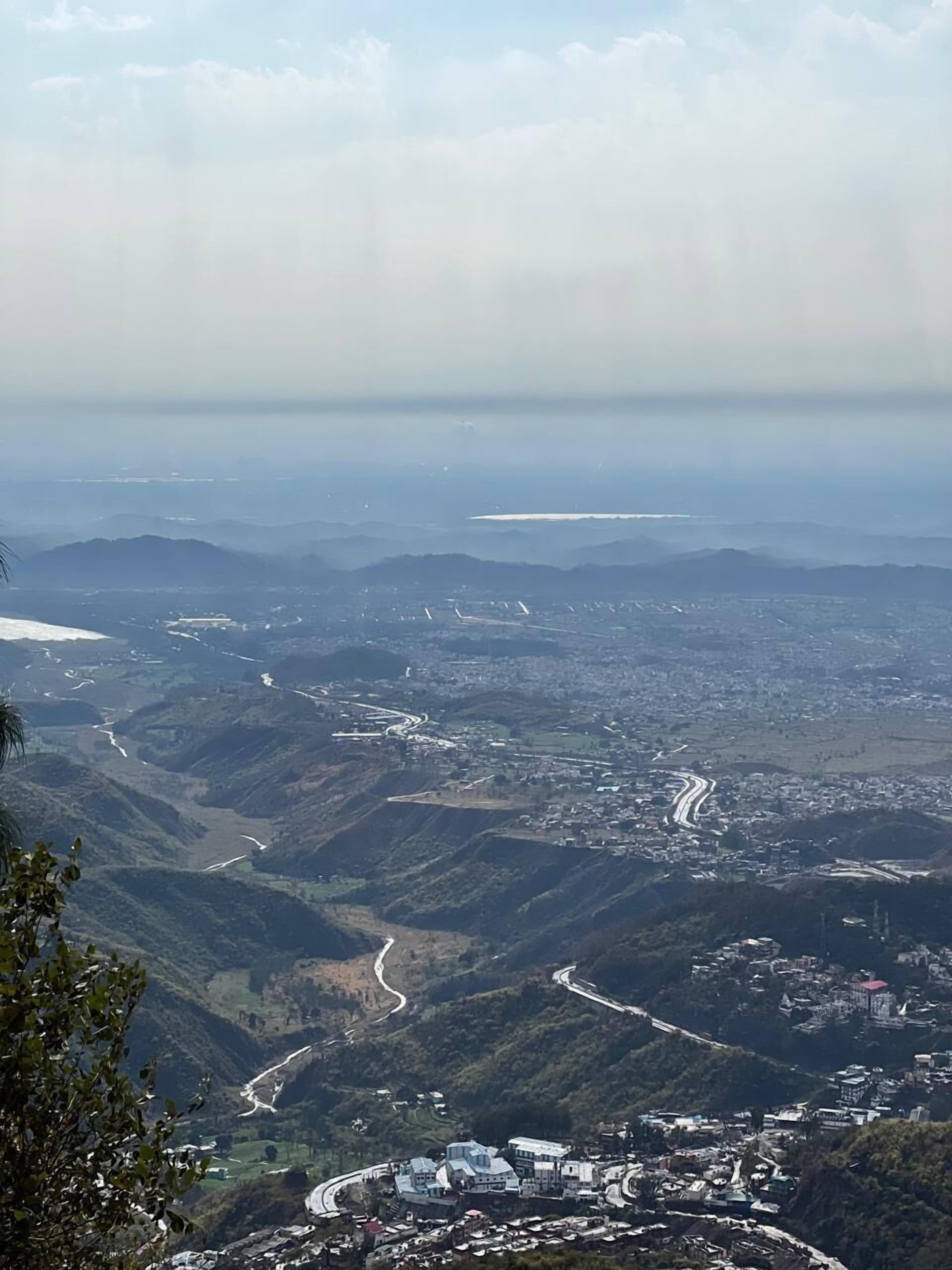 Paisaje montañoso con carreteras sinuosas y un pueblo ubicado en el valle.