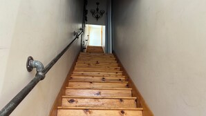 A wooden staircase with a metal handrail and a chandelier at the top. - Stunning river view loft in Wabasha near Eagle Center (Wabasha)