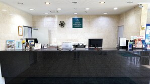 A reception area with a marble wall, a clock, and a sign for Aomori Forest Hotel Annex. - Aomori Forest Hotel Annex (Aomori)