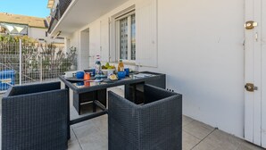 Ein Essbereich im Freien mit Korbmöbeln und einem Tisch, gedeckt mit verschiedenen Speisen und Getränken.