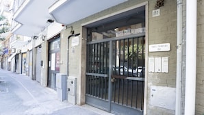 A building with a metal gate, a sign reading 'Via L. Guerrero 112', and a 'SET' sign on the wall. - GuestHost - Studio Apartment Gem: Compact Comfort Redefined (Salerno)