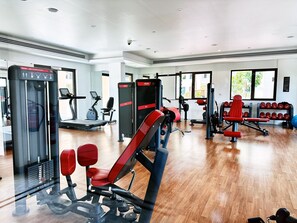 A gym with various exercise equipment, including treadmills, weight machines, and dumbbells. - Modern 4BR w/ Full Burj Al Arab View & Pvt Rooftop (Dubai)