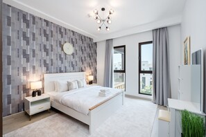 A modern bedroom with a bed, nightstands, a wall clock, a chandelier, and a large window with curtains. - Modern 4BR w/ Full Burj Al Arab View & Pvt Rooftop (Dubai)