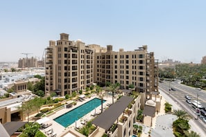 A high-rise hotel with a rooftop pool, multiple balconies, and a view of the cityscape. - Modern 4BR w/ Full Burj Al Arab View & Pvt Rooftop (Dubai)