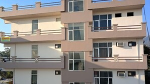 A multi-story building with a flat facade, multiple windows, and balconies. - Hotel Sunshine (Reasi)