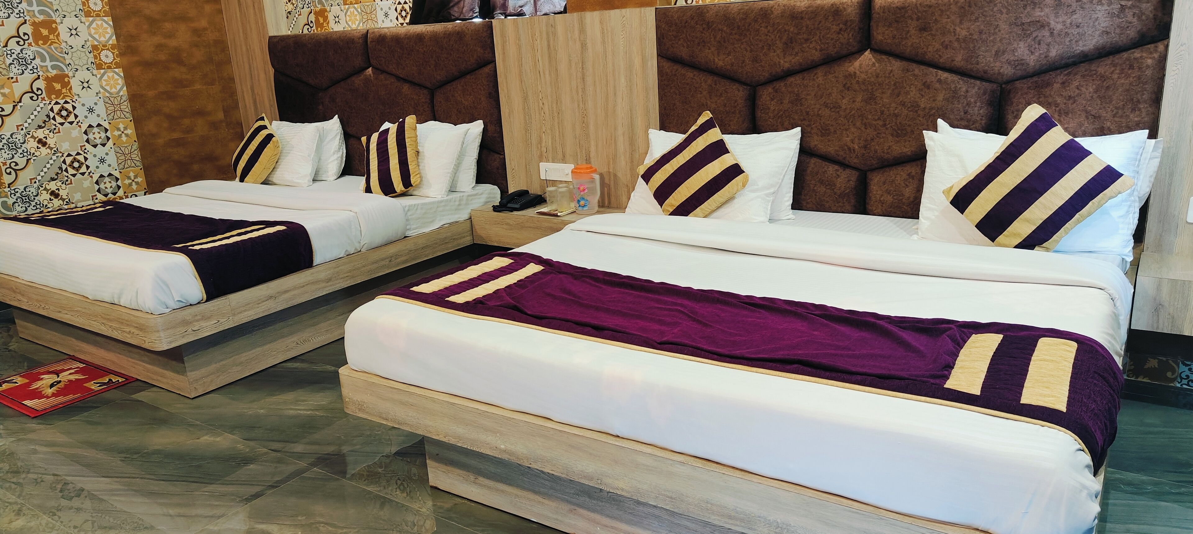 Two double beds with wooden frames, white bedding, and striped pillows.
