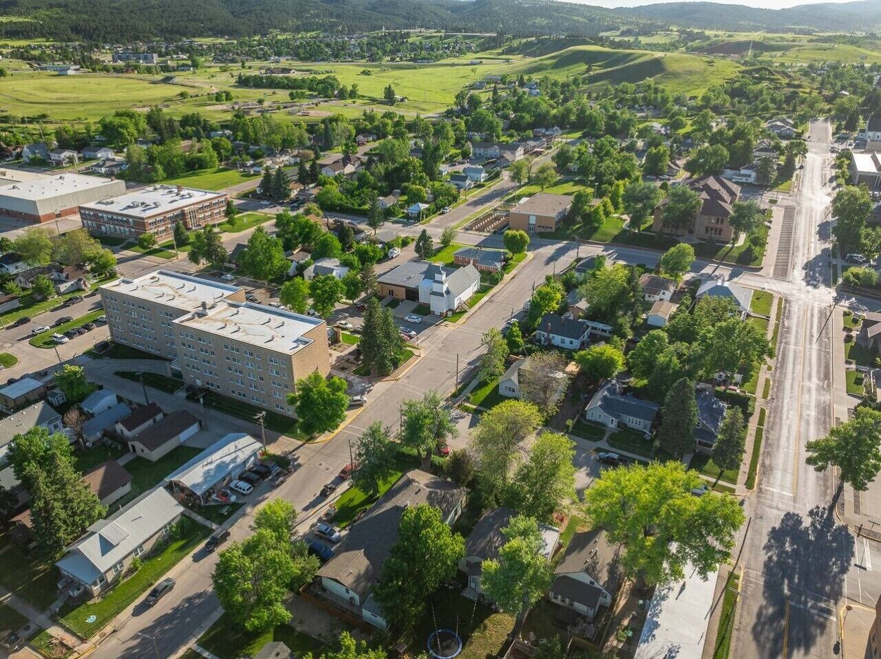 A residential area with a large building, likely a school or community center, surrounded by houses and streets.