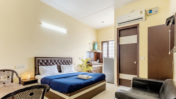 Habitación de hotel con una cama, un escritorio, una silla, un sofá y una mesita.