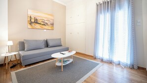 Una sala de estar moderna con un sofá gris, una mesa de centro blanca y un cuadro en la pared.