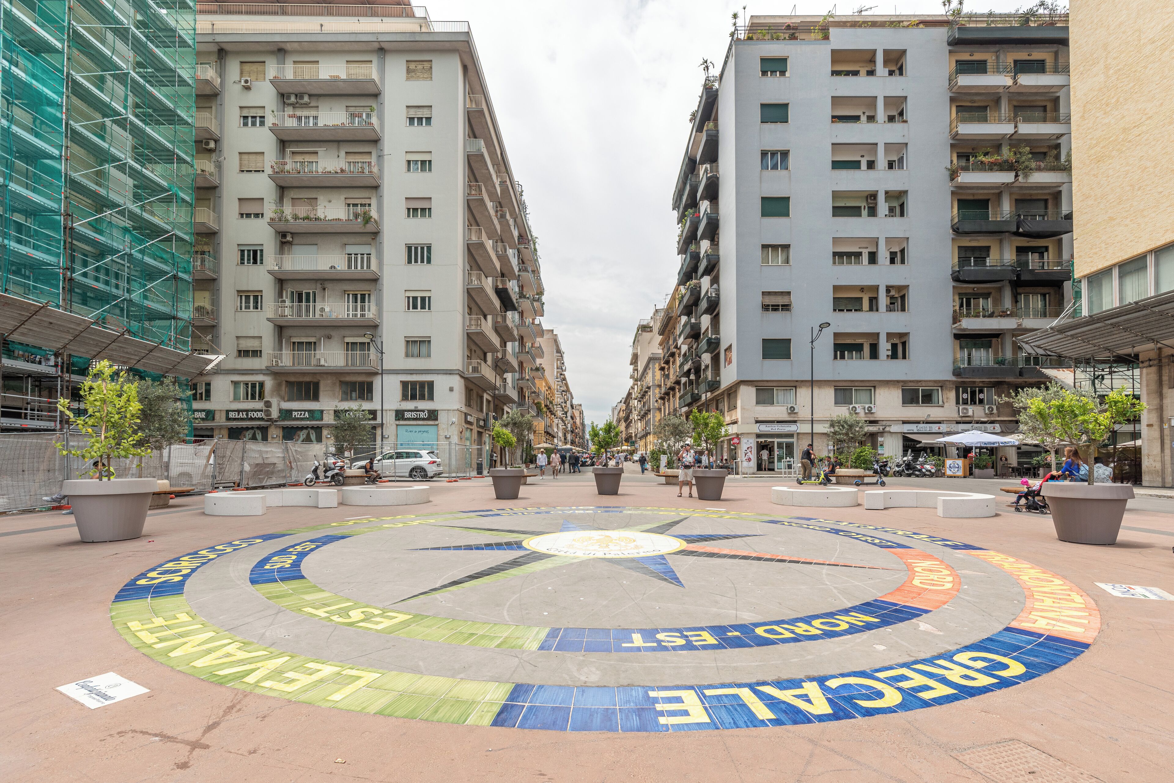 Ett runt torg med en stjärnformad design och texter på flera språk.