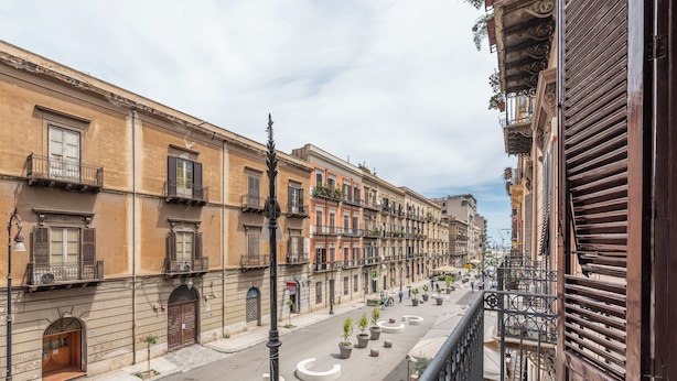 A street with buildings, circular planters, and a balcony. - Amari Elegant Apartment by Wonderful Italy (Palermo)