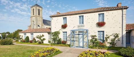 A building with a church tower, a glass entrance, and flower boxes.