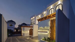 A modern villa with a well-lit entrance, large windows, and a name sign. - Onnea Villa by Lead (Canggu)