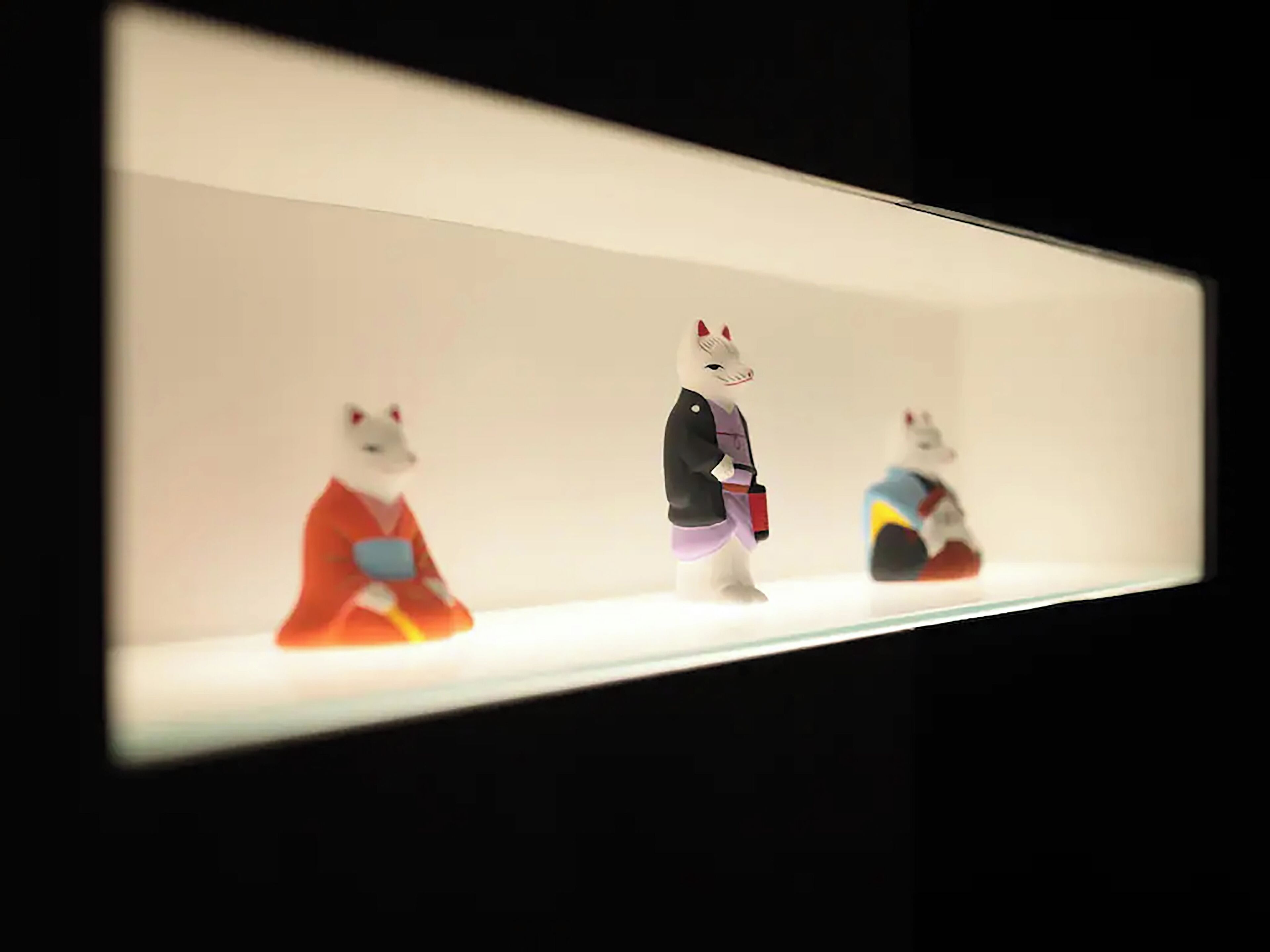 Three figurines on a shelf.