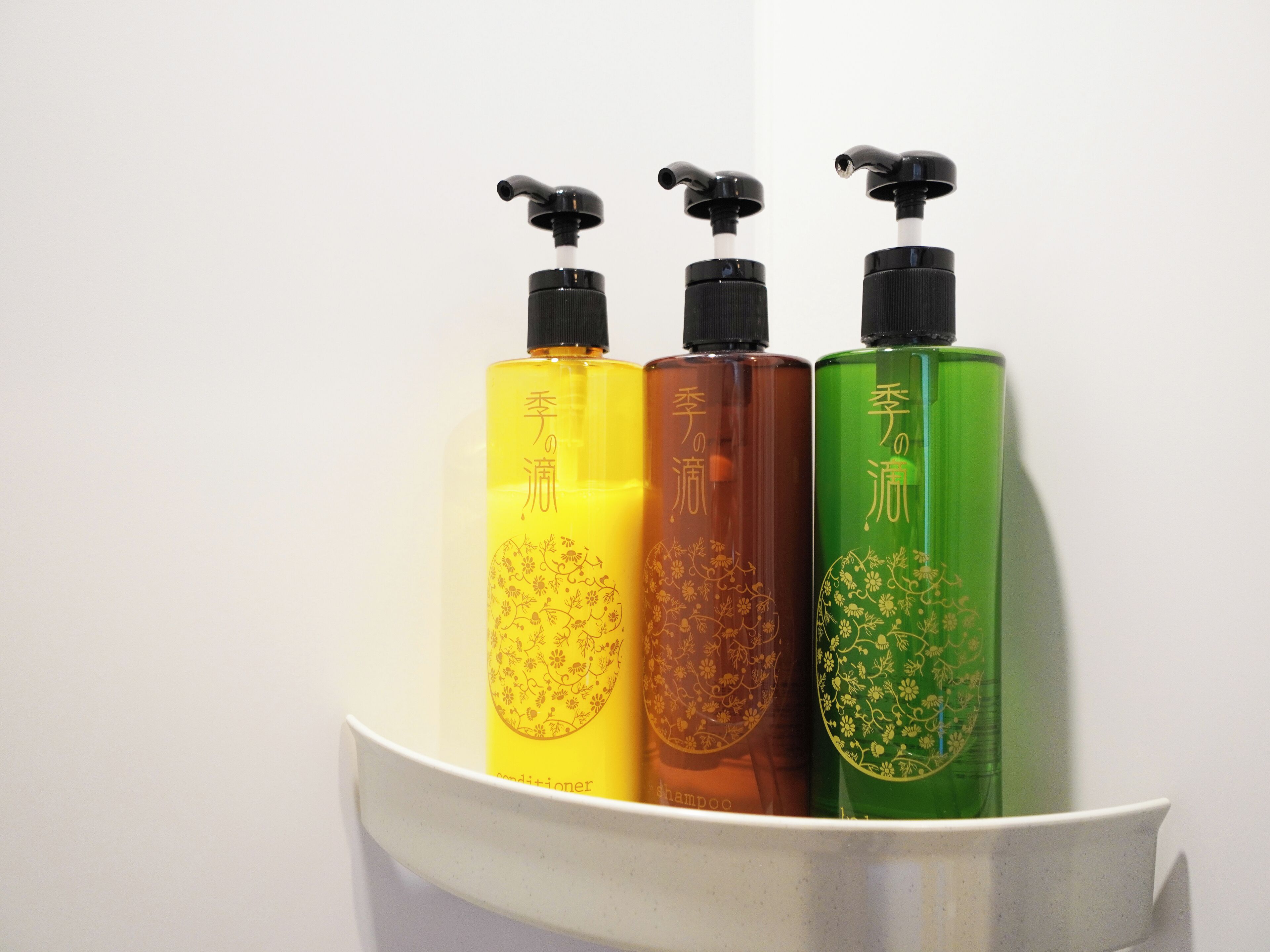 Three bottles of liquid in a white container.