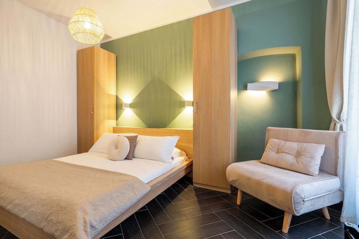 Ein modernes Hotelzimmer mit Bett, einer Sitzecke und einer Wandleuchte.
