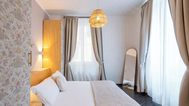A neatly made bed with a headboard, a bedside lamp, and a hanging light fixture. - I Remi del Prione by Le 5 Terre (La Spezia)