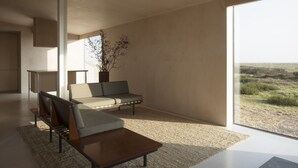 Een moderne woonkamer met een bank, salontafel en uitzicht op de omgeving.