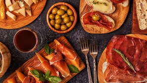 A variety of food items including bread, cheese, olives, and cured meats arranged on wooden boards. - Appartamenti Giada Studio Apartment 4 Pax Casa Giada (Moneglia)