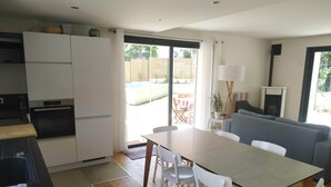 A compact kitchen with modern appliances, a dining area with a table and chairs, and a living room with a sofa and a TV. - House near Aix en Pce and Marseille + Clim (Cabriès)