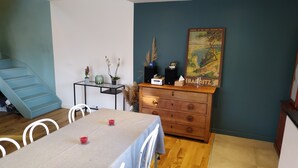 A dining area with a table set for four, a wooden dresser, a painting on the wall, and a staircase. - House near Aix en Pce and Marseille + Clim (Cabriès)