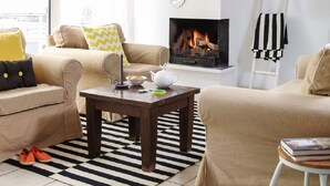 A cozy living room with a fireplace, a coffee table, and two sofas. - Penthouse in Loosdrecht (Loosdrecht)