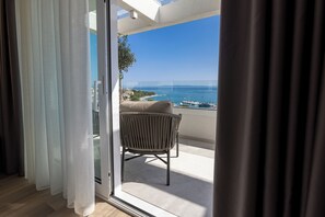 Un balcón con vista al mar y una silla.