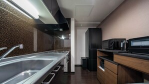 Una cucina moderna con lavelli in acciaio inossidabile, un forno a microonde e mobili in legno.